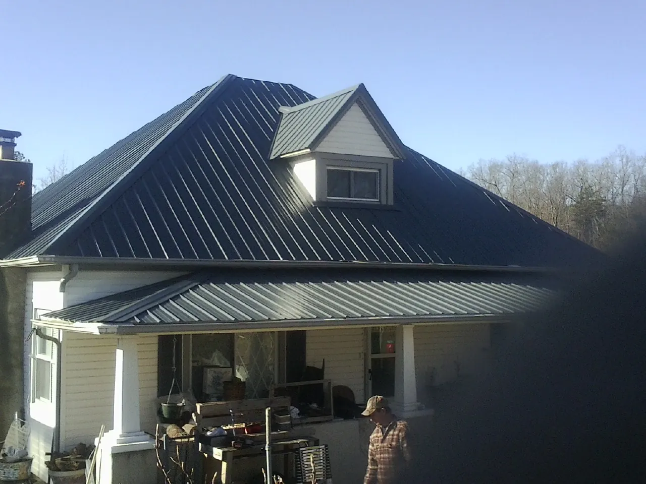 Dark blue standing seam metal roof with a dormer above a front porch in Kanarraville