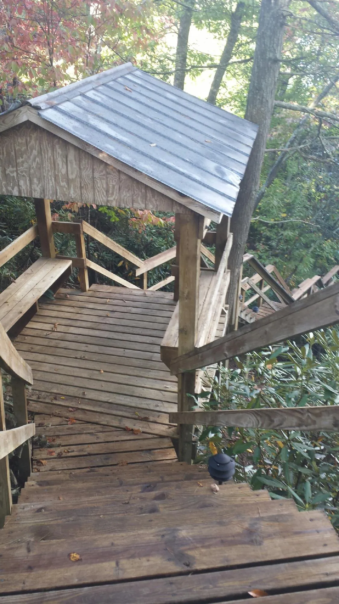 Metal roofed shelter over wooden steps on a wooded walkway — Skylight Repair & Installation work by our crew in Kanarraville