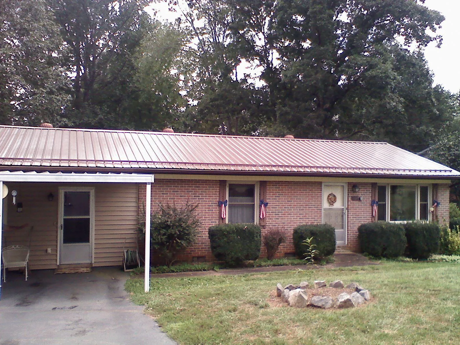 Bronze metal roof and carport on a brick ranch home — Roof Repair work by our crew in Kanarraville